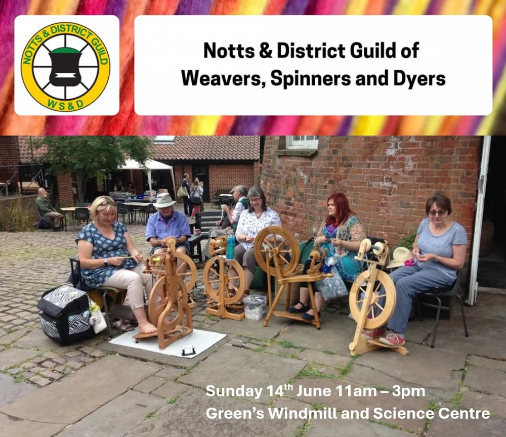 A group of people sat in a windmill courtyard spinning yarn