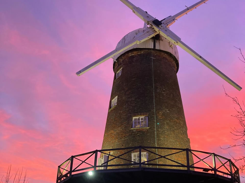 Green's Windmill with a purple and red sunset sky in the background