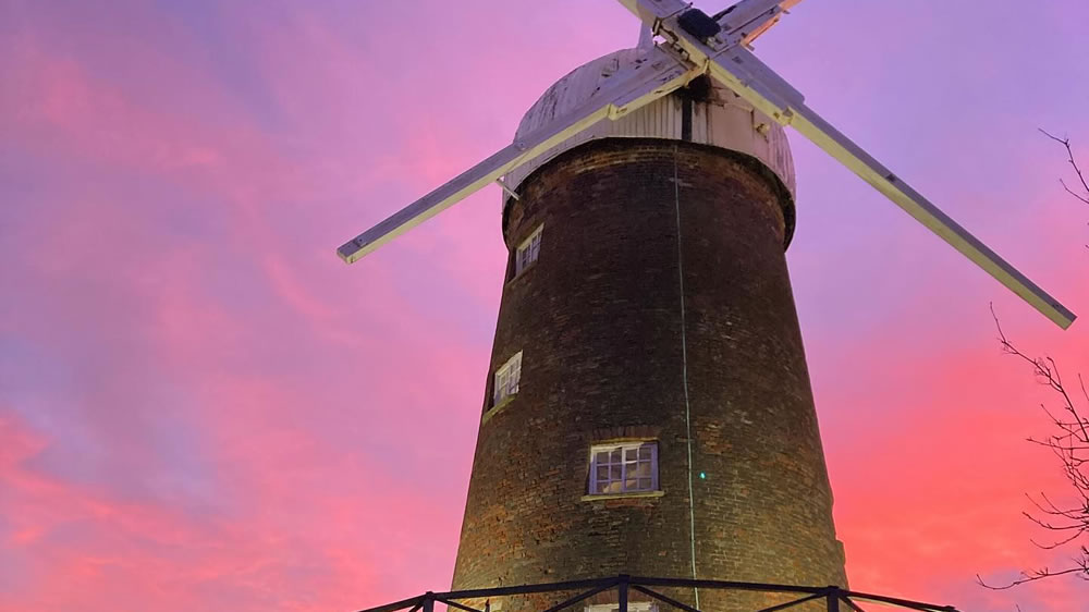 Green's Windmill with a purple and red sunset sky in the background